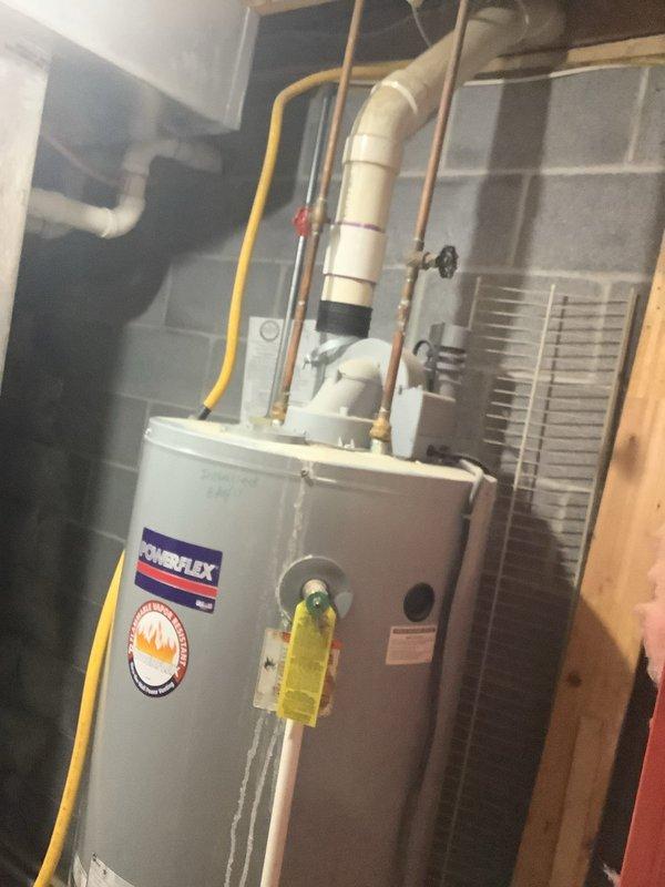 Replaced leaking natural gas power vent water heater with new unit, including installation of new expansion tank. The original water heater was failing at the base, necessitating complete replacement. Connected all necessary utilities including gas line, copper water supply lines, and PVC venting. Exercise caution with existing valve on top of old unit due to corrosion concerns to prevent additional water damage during removal.