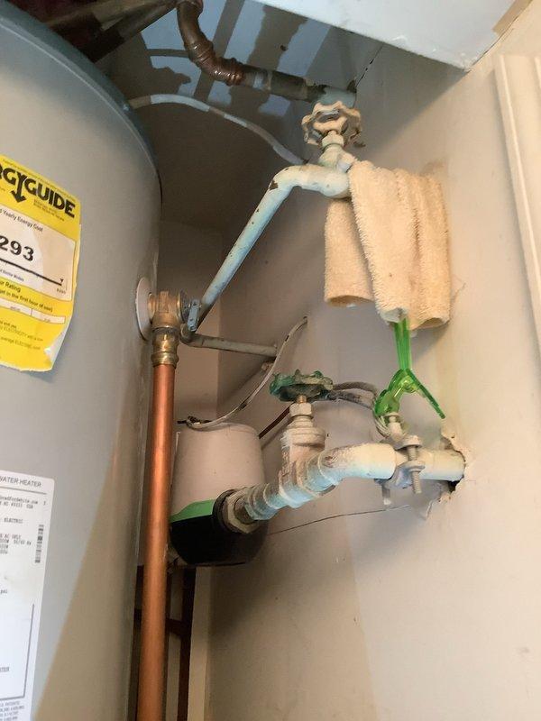 Coordinated with water company for street-side water shutoff at 8:00 AM to facilitate replacement of defective street-side valve. Replaced toilet in main warehouse facility and completed miscellaneous plumbing repairs. Inspected and documented water heater installation connections including copper piping, PEX tubing, ball valves, and pressure tank components to ensure proper operation following water service restoration.