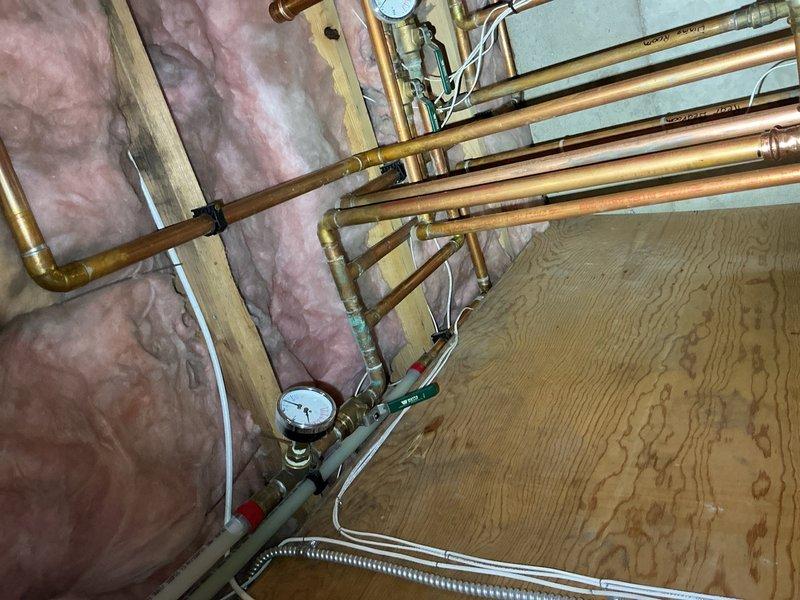 Responded to after hours emergency call for hydronic heating system issue. Upon arrival, inspected the manifold distribution system and associated copper supply piping in the mechanical space. Found pressure irregularities at the main distribution manifold serving multiple heating zones. Verified all PEX circuit connections at the manifold assembly and checked pressure gauge readings. Adjusted zone valves and bled air from the system to restore proper circulation. Confirmed all four heating circuits were functioning correctly and maintaining appropriate pressure levels before departing the premises.
