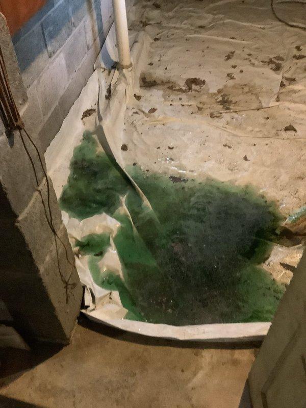 Responded to a call for a toilet leaking into the basement, confirmed by blue-tinted water visible below. Upon inspection, discovered a severely corroded and rusted toilet flange with significant deterioration at the floor connection point. Removed the toilet to access the damaged flange, replaced the failed flange with new hardware, installed a new wax ring seal, and properly re-set and secured the toilet to restore proper function and eliminate the leak.