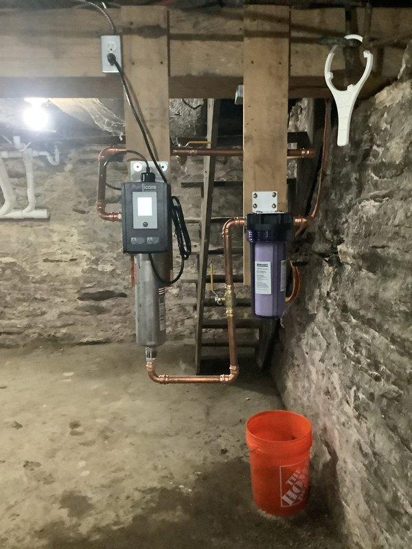 Installed a complete water treatment system in basement consisting of a UV water disinfection unit and whole house filtration system. Integrated both units into existing copper supply lines with new shut-off valves, brass fittings, and proper mounting hardware secured to wooden backing boards on foundation wall. Configured plumbing to allow UV disinfection following filtration stage, ensuring optimal water quality throughout the residence.