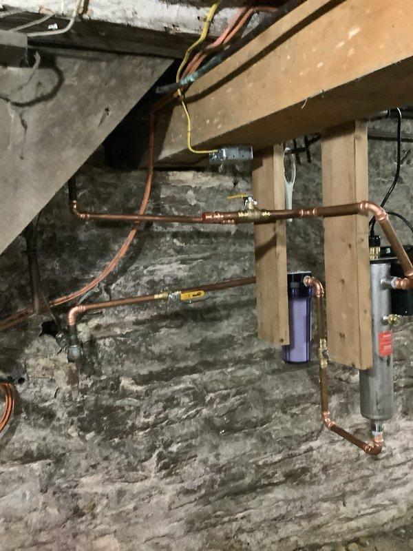 Installed a complete water treatment system in basement consisting of a UV water disinfection unit and whole house filtration system. Integrated both units into existing copper supply lines with new shut-off valves, brass fittings, and proper mounting hardware secured to wooden backing boards on foundation wall. Configured plumbing to allow UV disinfection following filtration stage, ensuring optimal water quality throughout the residence.