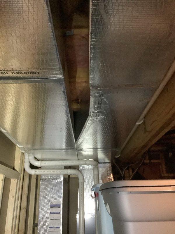Responded to water leak in basement originating from ceiling area. Located source of leak in copper supply piping running above ductwork in unfinished section of basement, with water traveling along piping into finished area. Opened section of ceiling to access and confirm leak location. Copper piping positioned directly above duct board ductwork, creating access challenges for repair work. Documented conditions with photos showing foil-faced insulation, copper piping, PVC drainage system, and HVAC components in mechanical space. Additionally replaced supply line to upper floor sink. Discussed future scope including potential ductwork removal for proper access to copper piping, ice maker supply line upgrade to stainless steel braided line, and heat system inspection to be scheduled separately.