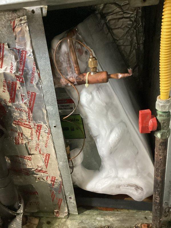 Responded to service call for Gibson AC unit (2013) with reported weak airflow and insufficient cooling. Upon inspection, discovered significant frost and ice accumulation on evaporator coil and refrigerant lines, indicating potential refrigerant leak or system restriction. Performed system diagnostics and obtained customer approval to proceed with refrigerant recovery and nitrogen pressure leak search test to identify source of system malfunction and determine necessary repairs.