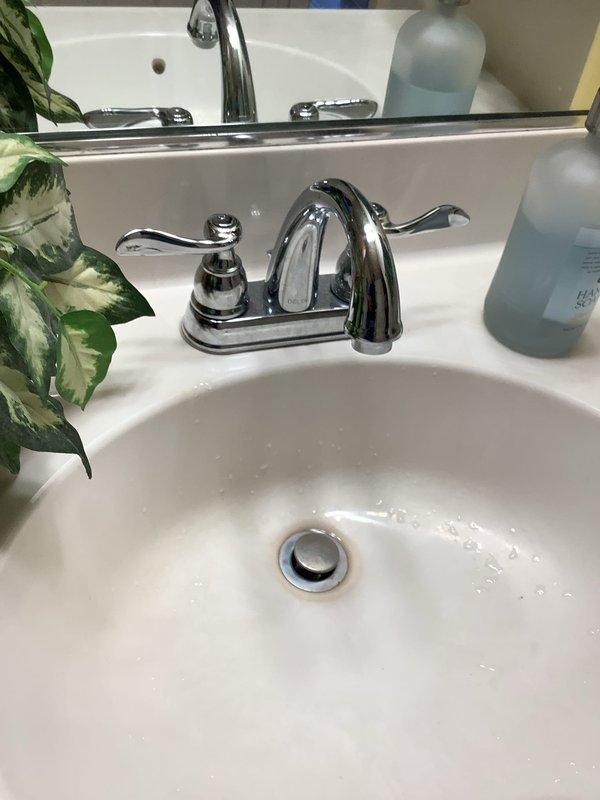 Replaced three lavatory faucets and one kitchen faucet with new chrome fixtures, ensuring proper installation and water flow. Installed new Toto 1.6 gallon per flush elongated white toilet after inspecting existing flange condition and verifying shut-off valve functionality. Inspected multiple hot water faucets throughout the property for leaks, tested water treatment system operation, and documented conditions with photographs.