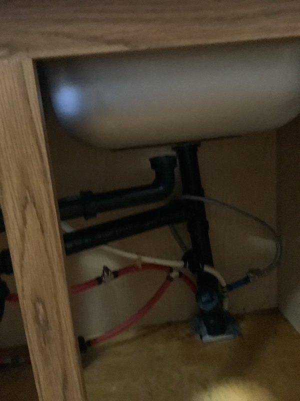 Installed customer-provided kitchen faucet on newly installed countertop with double-basin stainless steel sink. Connected water supply lines and completed drain line installation, including integration of dishwasher drain connection to the system. All plumbing connections tested and verified for proper operation with no leaks detected.