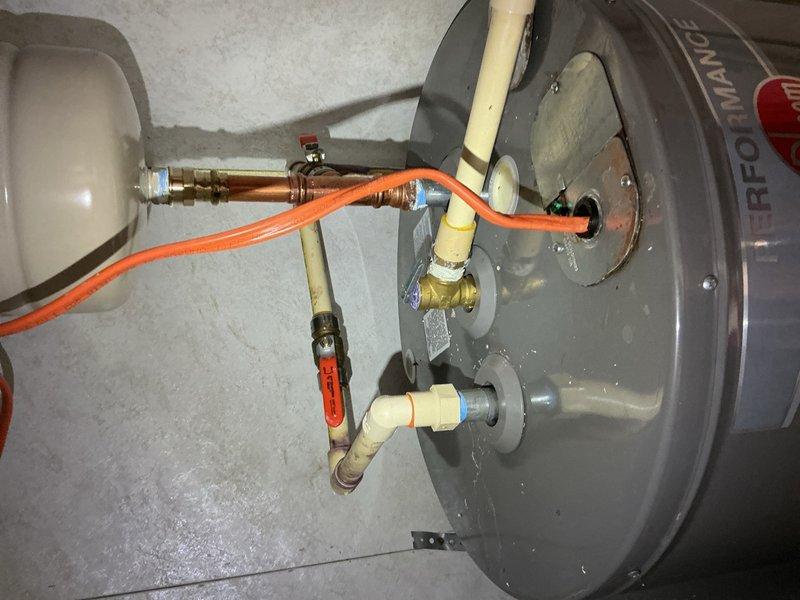 Responded to service call for water heater leaking at top of unit. Upon inspection, identified leak originating from plumbing connections at top of Rheem Performance Platinum electric water heater. Assessed all copper pipe fittings, brass valves, expansion tank connections, and pressure relief valve discharge piping. Tightened loose fittings and verified proper sealing of all connections. Tested system operation and confirmed leak was resolved with no further water discharge observed.