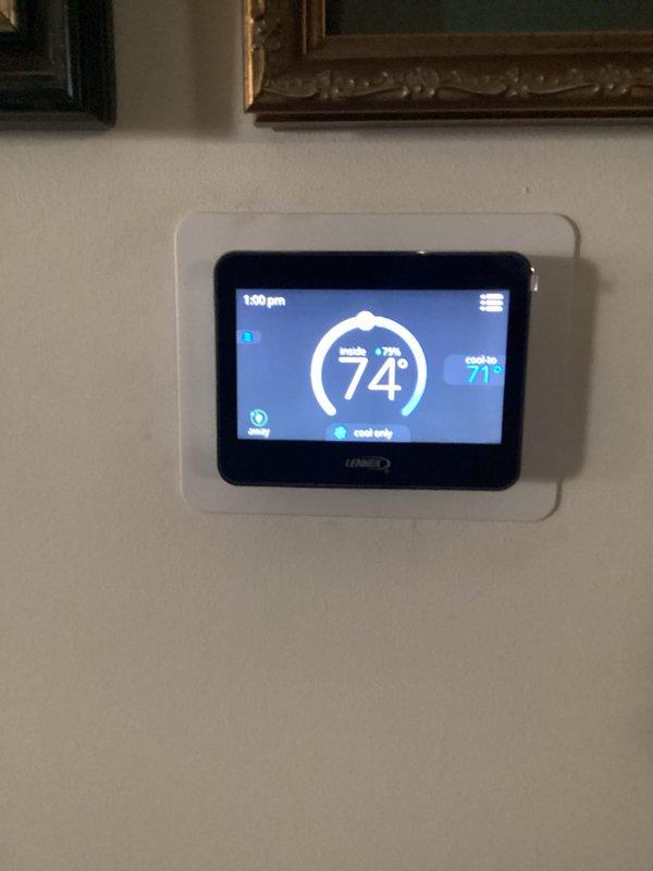 Responded to no-cooling complaint on Lennox AC system installed in September 2019. Upon arrival, verified thermostat was calling for cooling with setpoint at 71°F and indoor temperature reading 74°F in cooling mode. Inspected indoor air handler wiring and heat strip connections, confirmed all electrical connections secure with proper wire nutting. Customer had already replaced filter prior to service call. System was operational but failing to provide adequate cooling; performed diagnostic evaluation of thermostat operation and electrical components to identify cause of cooling failure.