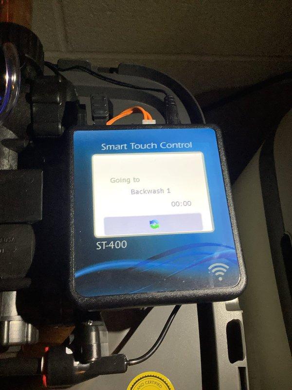 Completed water treatment system installation re-check and verified proper operation of the Smart Touch Control ST-400 unit. Performed water quality testing and documented system components including copper refrigerant lines, compressor assembly, and backwash cycle functionality to ensure installation meets specifications.