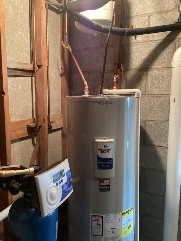 Responded to service call for leaking 50-gallon electric water heater in residential basement. Upon inspection, confirmed active leak requiring full unit replacement. Removed existing Bradford White water heater and installed new 50-gallon electric water heater with adequate clearance specifications (23" width, 58" height). Connected copper supply lines, verified proper electrical connections, and tested all plumbing connections for leaks. System commissioned successfully with no issues detected.