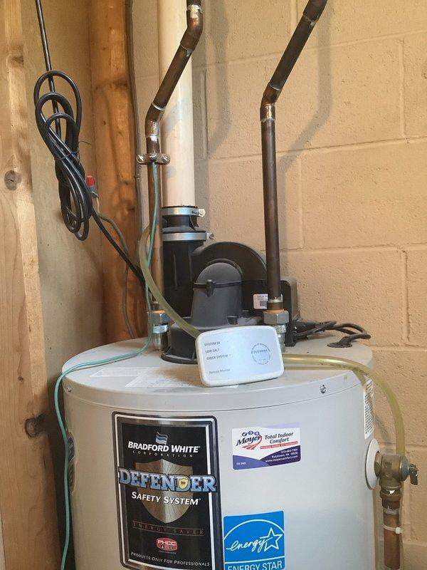 Replaced 16-year-old water treatment system that experienced significant water leakage into drain following reset button activation. Original unit had been placed in bypass mode to control leak, with display screen and keypad buttons deteriorated and difficult to read due to age. Evaluated leaking copper fitting in basement and inspected existing 16-year-old Bradford White water heater during service visit. Completed full system replacement installation with new water treatment equipment, ensuring proper connections to existing plumbing infrastructure and verifying all components functioning correctly without leaks.