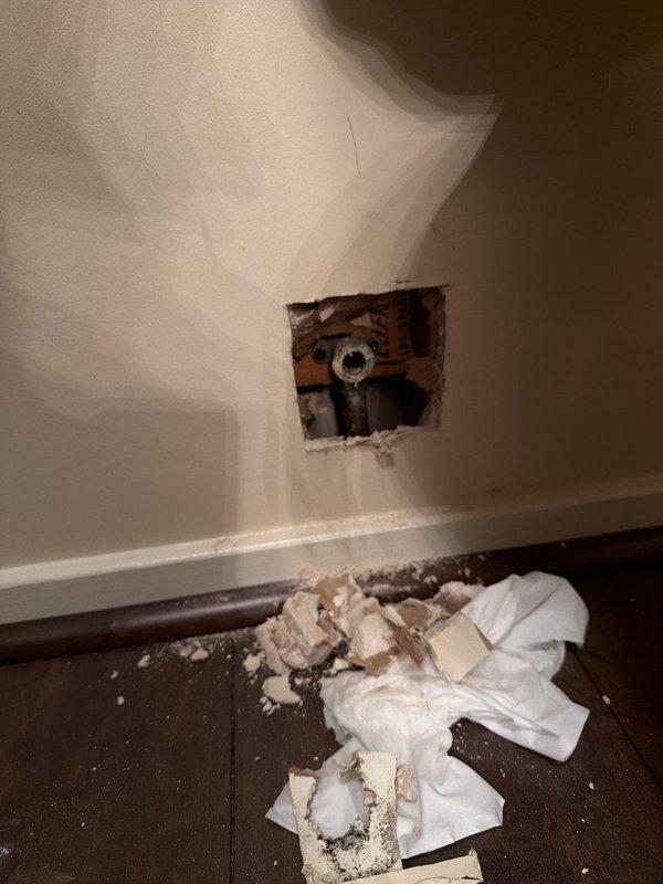 Responded to two plumbing concerns: investigated intermittent high-pitched humming noise occurring when multiple water fixtures were in use, which stopped when powder room toilet was flushed. Accessed plumbing system through drywall opening to diagnose water hammer issue and inspected valve assembly. Additionally addressed sewage odor in main bathroom by examining drain system and replaced defective valve fixture to resolve both the noise issue and potential venting problem causing the odor.