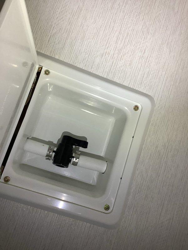 Responded to emergency call for leaking main water shut-off valve. Upon arrival, confirmed water was already shut off at exterior main to control active leak. Replaced faulty main shut-off valve assembly with new brass ball valve with red handle. Installed valve within recessed wall access panel box with proper gasket seal and secured with white PVC connections on both sides. Tested valve operation, confirmed no leaks, and restored water service to property.