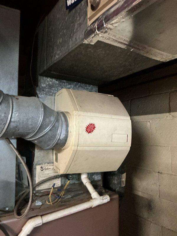 Responded to service call for oil heating system not operating after homeowner replaced thermostat batteries. Upon arrival, found Honeywell Home Pro Series digital thermostat displaying numbers but system failing to call for heat. Verified thermostat was receiving power and display was functioning properly at 71 degrees in heat mode with fan set to auto. Inspected basement mechanical room and examined oil-fired heating system, humidifier unit, and associated ductwork connections. Diagnosed thermostat programming issue following battery replacement which reset system settings. Reprogrammed thermostat to correct parameters and verified proper communication between thermostat and heating system. Cycled system through complete heating cycle to confirm proper operation and heat delivery throughout home.