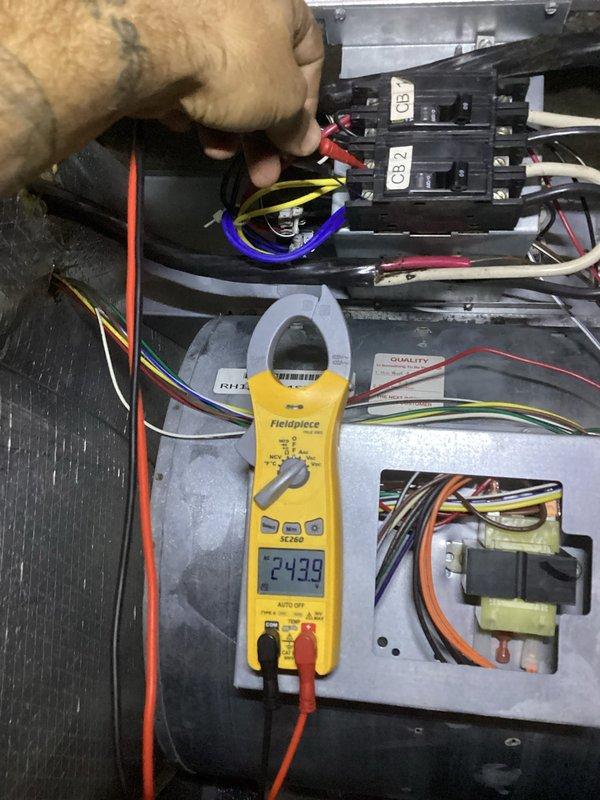 Responded to a callback for a boiler leak and loss of hot water. Performed electrical diagnostics, measuring condenser compressor circuit amperage (9.13 A) at the contactor and capacitor section, and verifying control voltage (approx. 24 V) at the air handler transformer and circuit breakers to confirm proper electrical operation.