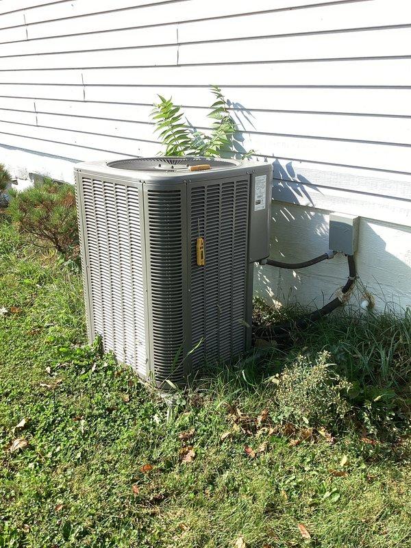 Performed a seasonal tune-up on the Lennox air conditioning system, inspecting the outdoor condenser unit, fan assembly, electrical disconnect, and conduit connections. Noted heavy vegetation growth against the condenser sides and recommended clearing weeds and debris to restore proper airflow and clearance. Verified system performance and calculated operating readings to confirm the unit is functioning within normal parameters.