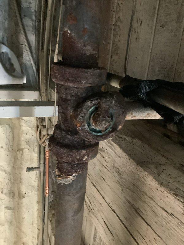 Drained the boiler loop and replaced the leaking, corroded steel main tee by cutting out the failed fitting and surrounding pipe, then installing a new reducing tee with the necessary threaded and Mega-Press fittings. Refilled the heating system and purged air from the loop to restore proper circulation and operation.