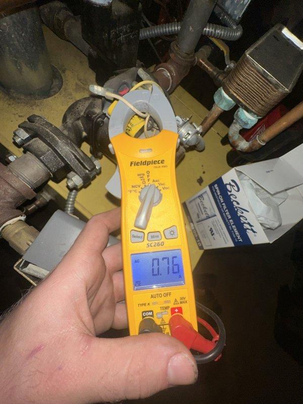Performed a complete oil burner tune-up on the existing Kneck 2000 unit, including cleaning the heavily sooted flue pipe and burner components, replacing the nozzle with a .75 x 70B, and installing a new Beckett spin-on pressure filter element. Verified burner motor operation with an amperage reading of 0.76 A, confirming normal electrical draw.