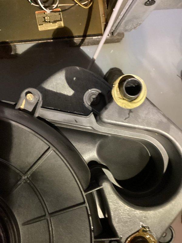 Performed a gas furnace tune-up and inspection in response to a reported water leak, finding water pooled around the base of the natural gas unit. Inspected the interior components, including the inducer blower housing and plastic collector box, where a hairline crack and sealant was noted near the condensate pipe fitting as a likely source of the leak. Verified operation with a digital thermometer probe on the ductwork (122°F reading) and completed the gas heating system check.