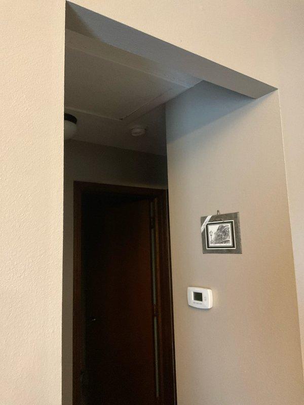 Conducted site assessment of residential property with existing boiler heating system to provide replacement options for AC installation. Inspected unfinished basement area with exposed joists and utility runs to evaluate potential installation pathways. Documented current thermostat location in hallway for integration with new AC system.
