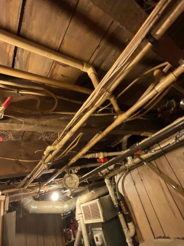 Conducted assessment for tankless water heater installation in mechanical room with existing HVAC system. Evaluated current plumbing configuration, including copper and PVC piping network running through basement ceiling joists, and noted multiple shut-off valves that would require integration with new system. Recommended appropriate tankless unit based on home's infrastructure and ventilation requirements.