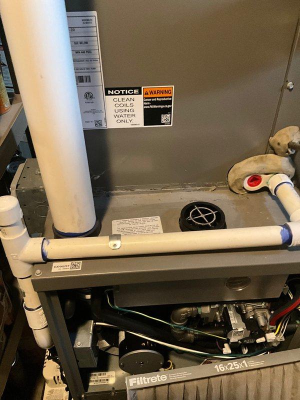 Performed routine maintenance on residential HVAC system (Club Heat 10-2). Inspected unit with visible "CLEAN COILS USING WATER ONLY" notice, examined PVC drainage connections with blue connectors, and verified proper installation of 16x25 Filtrete filter. Utilized specialized L-shaped hex tool for access to internal components during maintenance procedure.