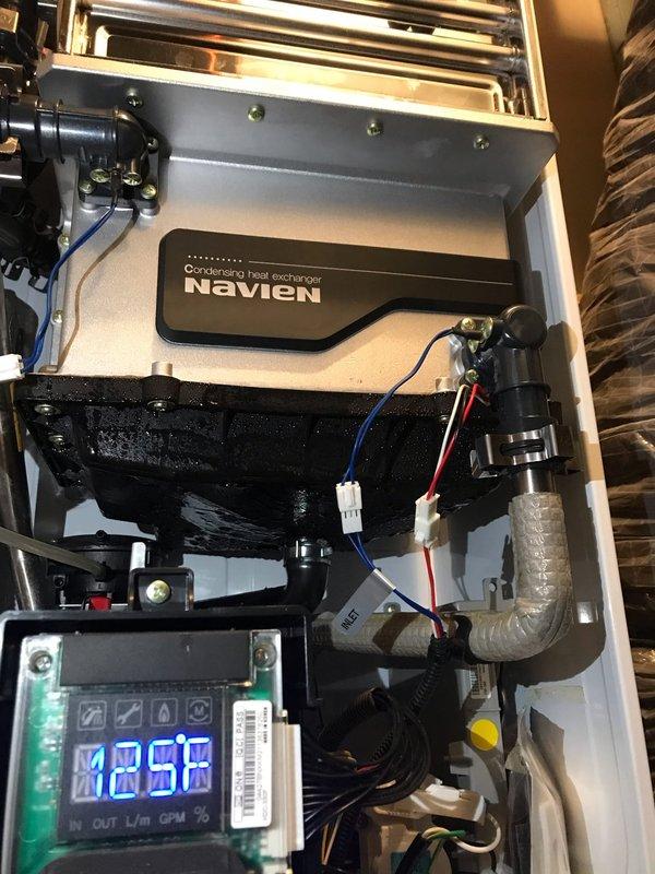 Diagnosed non-functioning Navien tankless water heater system. Inspected condensing heat exchanger and internal components, noting digital display readings of 188. Resolved operational issues and verified proper system functionality before completing service.