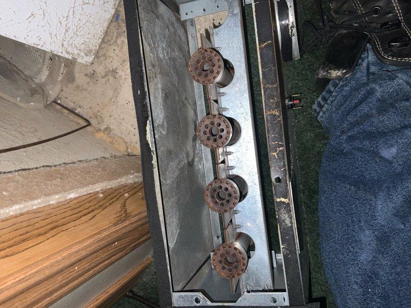 Responded to service call regarding non-functioning water heater. Upon inspection, identified heavily corroded burner assembly with significant oxidation on all four burner heads. Examined control board (NORDYNE) which showed functioning LED indicators but required cleaning of connection points. Replaced pilot assembly and verified proper ignition sequence and flame characteristics after installation.