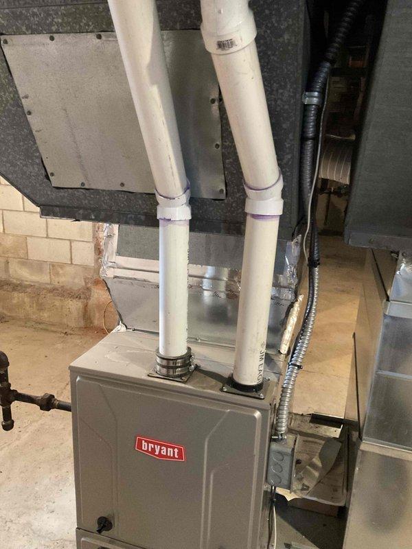 Conducted assessment of existing Bryant furnace installation in basement utility room. System features vertical PVC exhaust pipes, metal ductwork with appropriate connections, and appears to be properly installed with all necessary components including control panel and ventilation system. Client seeking quote for new AC unit installation to complement current heating setup.
