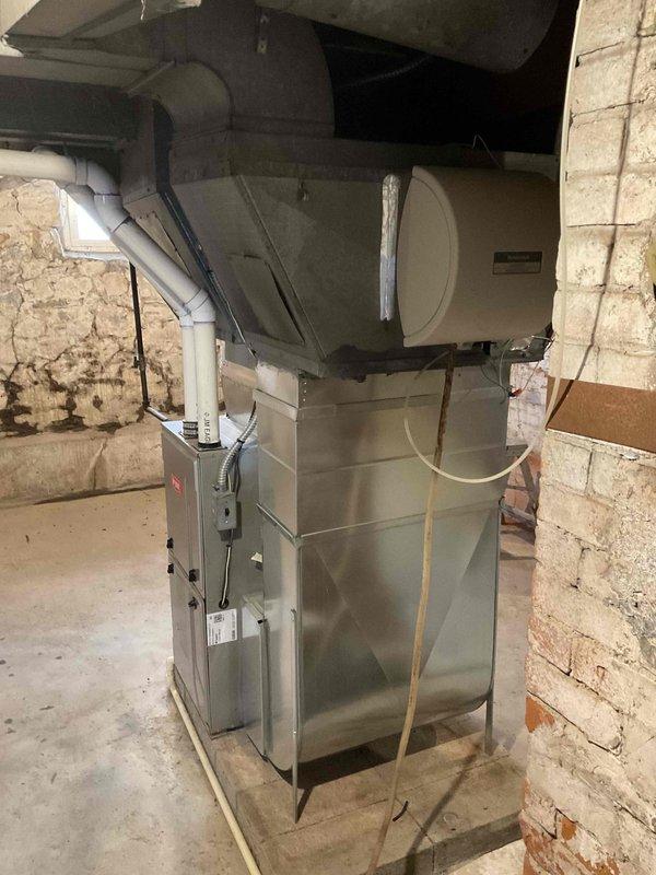 Conducted assessment of existing Bryant furnace installation in basement utility room. System features vertical PVC exhaust pipes, metal ductwork with appropriate connections, and appears to be properly installed with all necessary components including control panel and ventilation system. Client seeking quote for new AC unit installation to complement current heating setup.