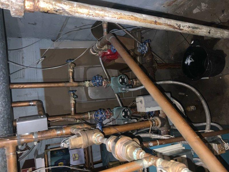 Responded to no-heat complaint for 10+ year old boiler system that was reportedly making ticking sounds while off. Inspection revealed extensive corrosion on copper pipes throughout the installation and confirmed abnormal noises emanating from the pressure regulation system. Replaced faulty pressure regulator and purged air from the system, which resolved the ticking issue and restored proper heating function.