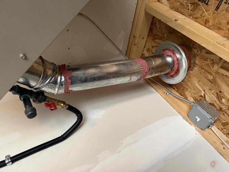 Responded to callback to address venting issues from previous installation. Rotated exterior vent tee to vertical position and extended it away from wall per permit requirements. Applied fire caulk to seal all venting joints for proper code compliance. Verified thermostat functioning correctly at 55°F in heating mode.