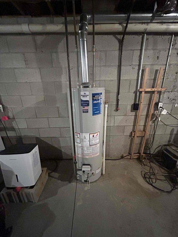 Successfully installed new tanked water heater in basement utility area, including proper connection of all supply lines and drain piping. Installed metal exhaust vent pipe with appropriate 90-degree bend, securing it properly to the concrete block wall. Verified all connections for leaks and confirmed proper operation before completion.