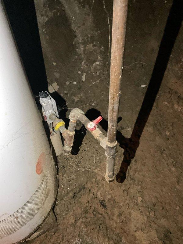 Conducted water heater assessment for CQ Quote #03552-02, inspecting existing unit in utility area. Observed aging tank with corrosion on connecting copper pipes, compromised valve system (red and yellow handles), and potential installation issues with the current setup. Recommended replacement with appropriate sizing and proper installation to ensure code compliance and optimal performance.