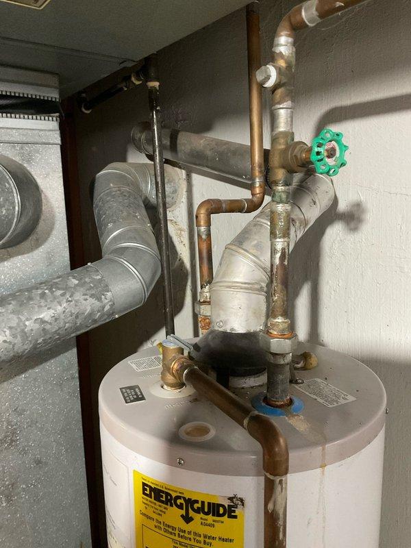 # Plumbing Estimate - Water Heater Replacement

Conducted on-site assessment for 40-gallon residential water heater replacement in basement utility room. Evaluated existing water heater installation, copper supply piping configuration, and venting requirements. Documented current plumbing connections including hot and cold water lines with shut-off valves, temperature and pressure relief valve discharge piping, and existing gas line routing. 

Inspected basement mechanical room layout and confirmed adequate clearances for new equipment installation. Noted existing water heater connections include copper supply lines with compression fittings, galvanized pipe sections, and multiple valve assemblies. Assessed condition of existing plumbing infrastructure and identified sections requiring replacement or modification during installation.

Prepared three separate quote options (03556-04, 03556-05, and 03556-08) for 40-gallon water heater replacement with varying specifications and installat