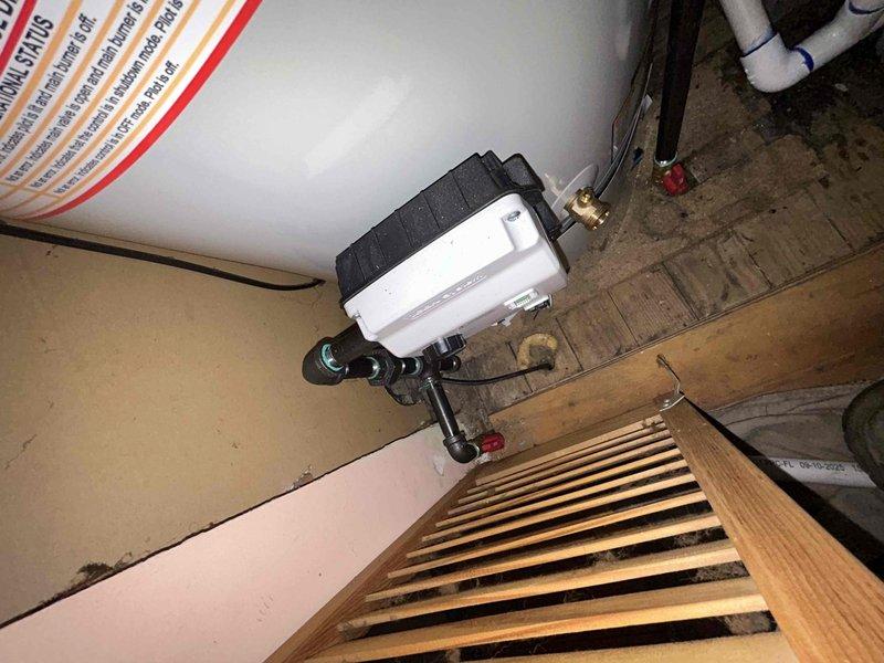 # HVAC Install - Furnace Service Summary

Completed installation of 70,000 BTU furnace and tankless water heater system in residential utility space. Successfully mounted tankless water heater unit to ceiling joists with proper copper supply line connections, brass shut-off valves, and PVC venting configuration routed through existing structure. Installed condensate drainage system using white PVC piping with serpentine routing to accommodate spatial constraints and ensure proper pitch for drainage. All mechanical connections secured and tested for proper operation prior to completion.