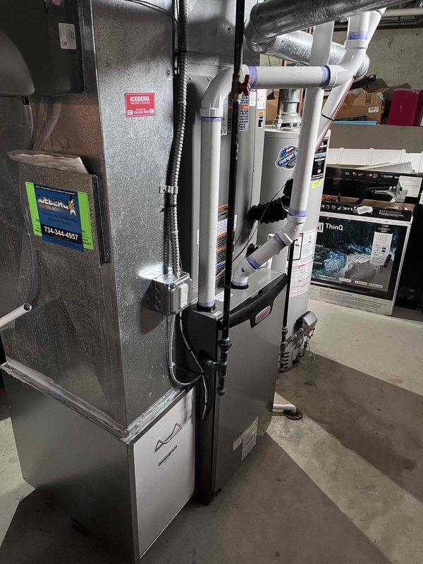 Completed full HVAC system installation including a 90,000 BTU furnace and 4-ton air conditioning unit with rear discharge configuration. Installation included all necessary mechanical and electrical connections, humidifier integration, white PVC venting system with proper drainage routing, and flexible metallic ductwork connections. All equipment secured with proper mounting hardware and brackets, system reconnected and verified operational in basement utility space.