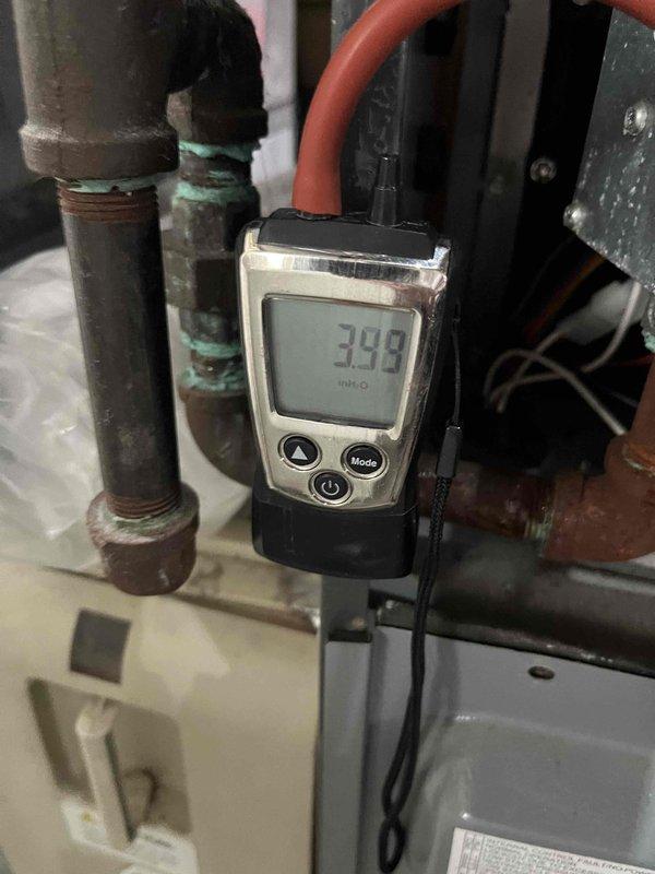 Completed preventive maintenance agreement visit for air handler and system inspection under Club Heat8-12 program. Performed diagnostic measurements and system evaluation, recording vacuum pressure readings of 398 InHg and 415 InHg at various test points throughout the HVAC system. Inspected copper refrigerant lines, noting visible corrosion and green patina buildup on pipe connections and threaded fittings, indicating age-related oxidation from moisture exposure. All mechanical components, piping connections, and system housing examined and documented with photos for maintenance records. System operational at time of departure.