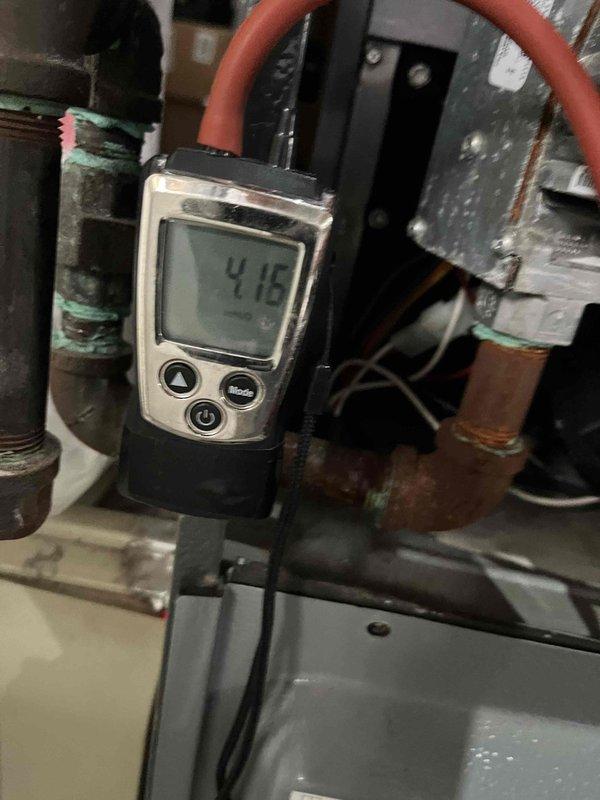Completed preventive maintenance agreement visit for air handler and system inspection under Club Heat8-12 program. Performed diagnostic measurements and system evaluation, recording vacuum pressure readings of 398 InHg and 415 InHg at various test points throughout the HVAC system. Inspected copper refrigerant lines, noting visible corrosion and green patina buildup on pipe connections and threaded fittings, indicating age-related oxidation from moisture exposure. All mechanical components, piping connections, and system housing examined and documented with photos for maintenance records. System operational at time of departure.