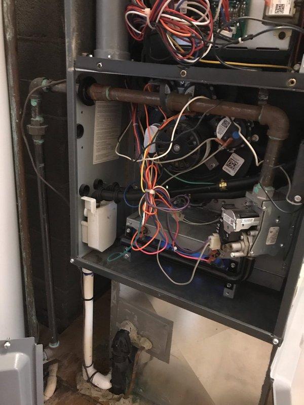 # HVAC Maintenance - Agreement Visit

Completed comprehensive maintenance inspection on residential split HVAC system including both indoor furnace unit and outdoor AC condenser. Performed thorough visual inspection of indoor air handler, examining all internal components including evaporator coil assembly, blower motor, control board, and refrigerant line connections. Verified proper wiring connections throughout system and checked all safety sensors and controls for proper operation.

Inspected outdoor condenser unit which showed significant accumulation of dirt and debris on exterior surfaces. Noted heavy dust buildup on condenser casing requiring attention to maintain optimal airflow and heat transfer efficiency. Examined electrical connections at outdoor unit and verified proper operation of condenser fan motor and compressor. Checked refrigerant line connections and condensate drainage system for proper function.

Documented system condition through photographic record showing in