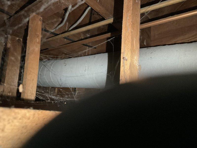 Completed HVAC estimate for ductwork replacement in attic crawl space. Inspection revealed existing metal ductwork suspended between structural joists with extensive cobweb accumulation indicating lack of recent maintenance, plus damaged drop ceiling section with sagging flexible ductwork requiring complete removal and reinstallation. Communication facilitated through phone translator to assess scope of work and document conditions for comprehensive ductwork replacement proposal.