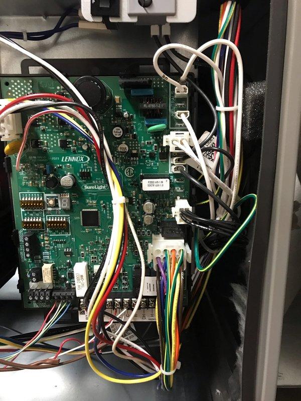 Completed Club AC12-4 agreement maintenance visit on Lennox HVAC system. Inspected furnace control boards and electrical connections, verified proper operation of SureLight control system, and examined all wire terminations at circuit boards and terminal blocks. Observed outdoor condenser unit with significant leaf debris accumulation around base and coil surfaces requiring attention during seasonal maintenance. Photographed control panel components and exterior equipment condition for service records.