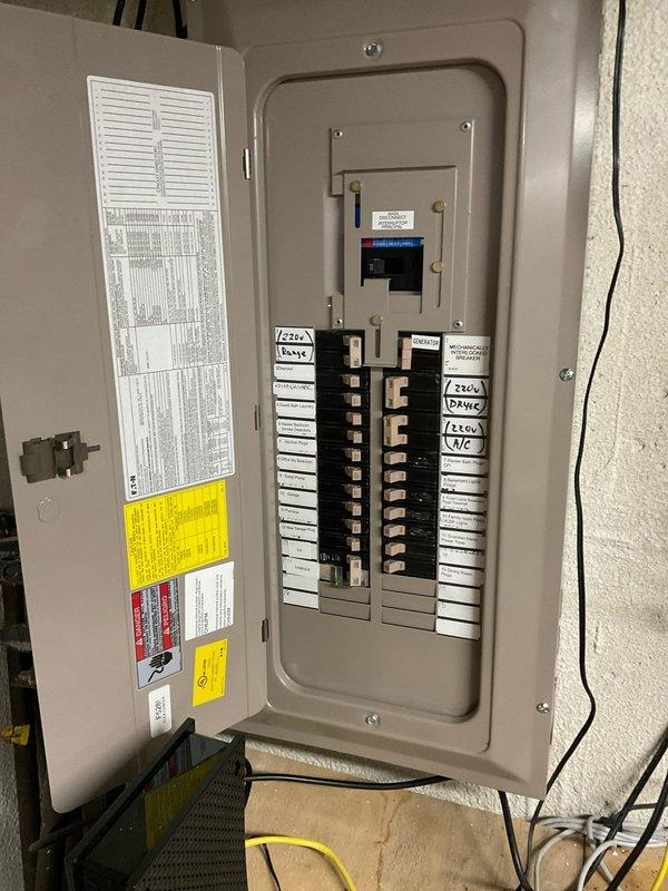 Conducted comprehensive site assessment for whole home generator installation at residential property. Evaluated existing electrical infrastructure including main service panel, meter base, and exterior utility connections to determine compatibility and capacity for generator integration. Documented current electrical panel configuration with multiple 220V circuits for range, HVAC, and appliances. Assessed optimal generator placement location adjacent to existing HVAC equipment on exterior brick wall, considering access to natural gas supply, electrical service entry point, and code-compliant clearances. Identified existing conduit pathways and junction box locations for transfer switch installation and generator connection. Photographed electrical panel interior showing circuit breaker arrangement and available capacity for automatic transfer switch integration. Evaluated site conditions including adequate workspace in mulched area near utility installations and confirmed structural r