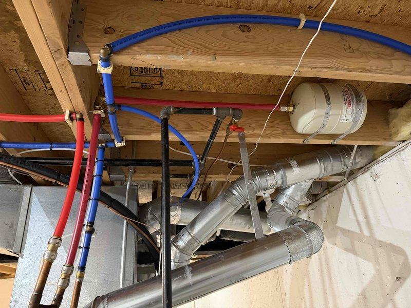 Responded to callback for expansion tank support installation to address permit compliance issue. Inspected residential HVAC system and plumbing configuration in basement mechanical room, verified proper support bracket installation for expansion tank mounted near water heater, and documented completed work with photographs showing furnace, ductwork, PEX supply lines, and properly secured expansion tank meeting code requirements.