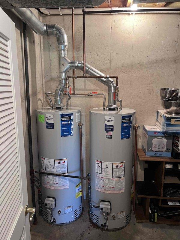 # Tanked Water Heater Installation

Completed professional installation of gas-fired tanked water heater system in basement utility area. Installation included proper venting configuration with metallic ductwork and exhaust piping, connection of copper supply lines with shut-off valves, and gas line hookup to burner assembly. All connections were secured per manufacturer specifications and local plumbing codes, with system tested and operational upon completion.