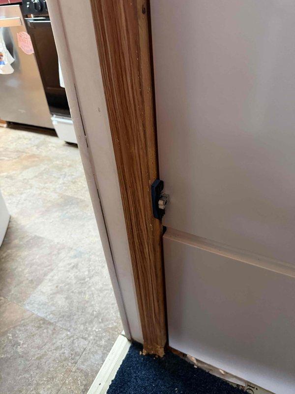 Responded to callback for furnace closet door alignment issue. Inspected louvered closet door and frame in hallway adjacent to kitchen area, verified door was not closing properly due to misalignment. Adjusted door hardware and strike plate to ensure proper latching and secure closure, restoring full functionality to furnace closet access point.