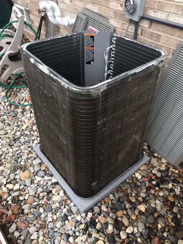 # Annual AC Maintenance Visit

Completed comprehensive annual air conditioning maintenance service as part of prepaid membership agreement. Upon arrival, performed thorough visual inspection of outdoor condenser unit positioned on gravel pad against exterior wall. Unit exhibited significant accumulation of dirt, dust, and environmental debris on condenser coils and fin assembly, indicating extended operation since last service.

Performed complete AC tune-up including the following procedures: inspected condenser unit exterior housing and verified structural integrity of mounting components and base pad. Examined electrical connections at outdoor unit and verified secure terminations. Assessed refrigerant line insulation and PVC condensate drainage system for proper installation and function.

Focused attention on heavily soiled condenser coil fins which displayed dark brown to black discoloration with substantial debris buildup between corrugated channels. Cleaned condenser coils usin