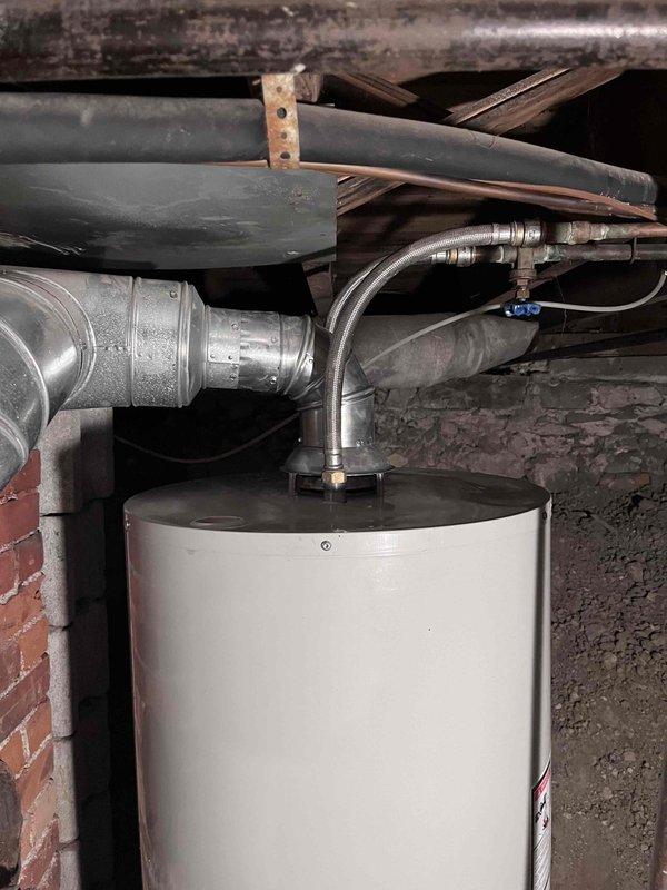 Completed installation of residential tanked water heater in crawl space area. Reconnected all water supply lines, gas connections, and exhaust piping to new unit, ensuring proper venting and secure mounting. System tested and verified operational with no leaks detected at connections.