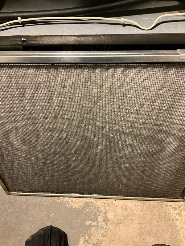 Performed routine AC tune-up and system inspection on residential air conditioning unit of unknown age. Inspected air handler and filter housing, documenting heavily soiled air filter with significant dust and debris accumulation requiring replacement. Evaluated system components including refrigerant lines, electrical connections, and ductwork connections. All accessible components photographed for maintenance records, with filter condition indicating extended service interval since last replacement.