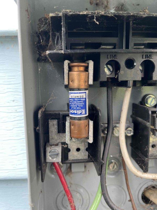 Completed preventative maintenance and tune-up on air conditioning system per agreement visit. Performed comprehensive inspection of outdoor condensing unit, measuring electrical parameters including amperage draw of 46.1 amps using clamp meter. Discovered significant contamination in exterior disconnect box, including spider webs, organic debris, and nesting material accumulated around Edison cartridge fuse and terminal blocks. Cleaned and cleared disconnect enclosure of all debris to prevent potential electrical failures and ensure safe operation. Verified all electrical connections at line terminals, inspected wiring integrity including line and ground conductors. Evaluated overall system condition and confirmed unit operational status suitable for cooling season.